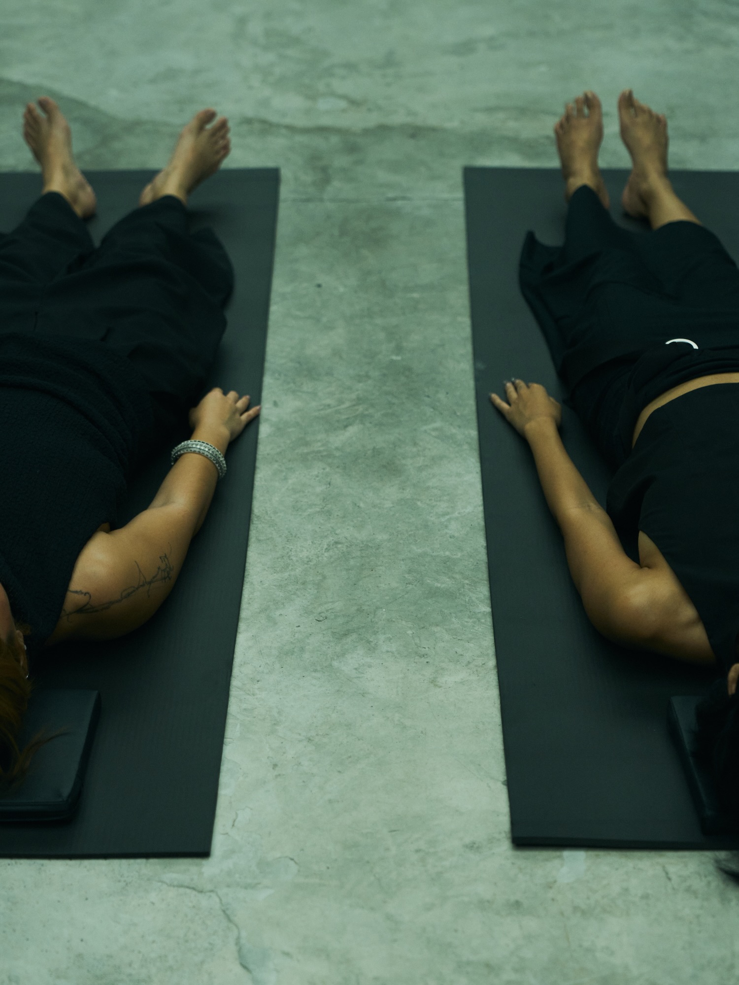 Two people lying on mats during a Hardcore Yoga Nidra session